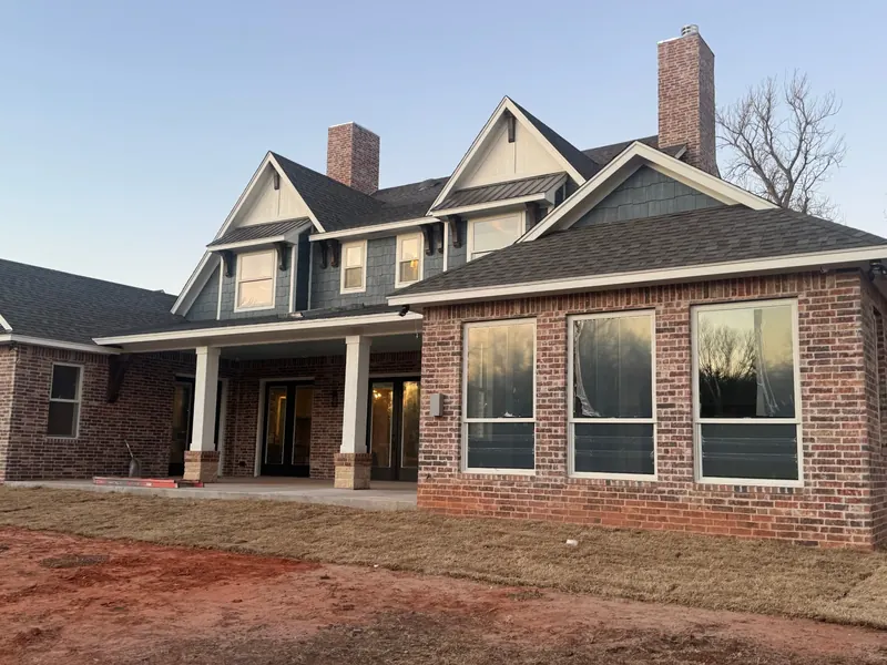 rear elevation with painted dormers and porch columns on a Moore OK home