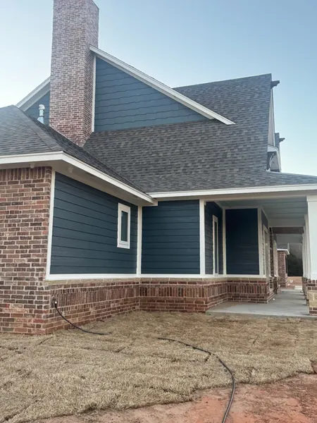 freshly painted navy lap siding and shake gable on an Oklahoma home