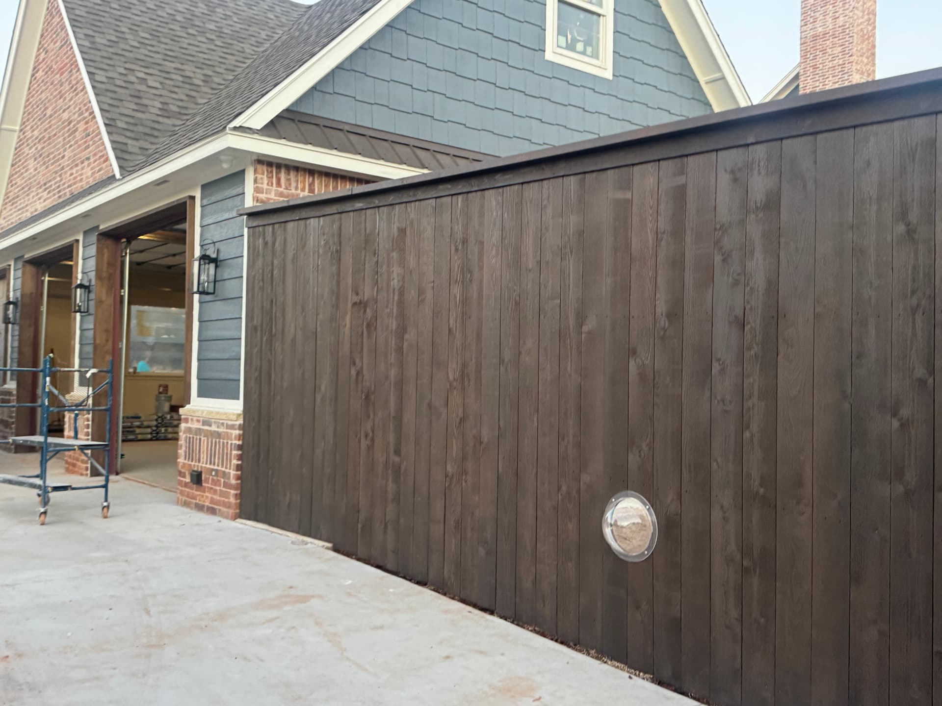 stained cedar privacy fence beside a painted navy home in Oklahoma